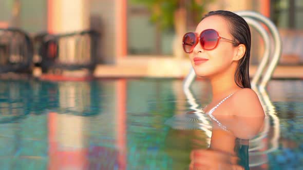 Young asian woman enjoy around outdoor swimming pool for leisure