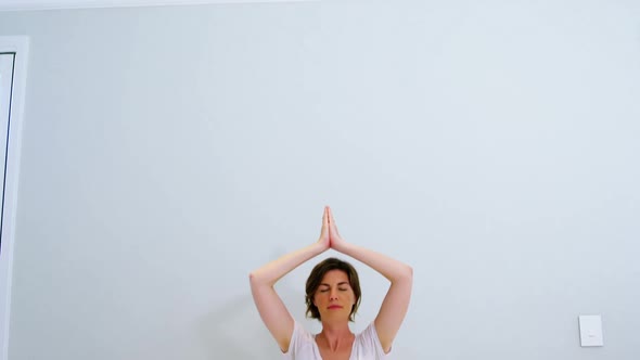 Woman practicing yoga in bedroom