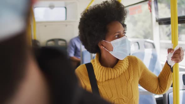 African american businesswoman with face mask standing in bus