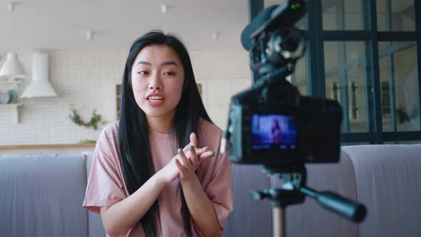 Popular Young Asian Woman Blogger Filming New Vlog Video with Professional Camera Mounted on Tripod