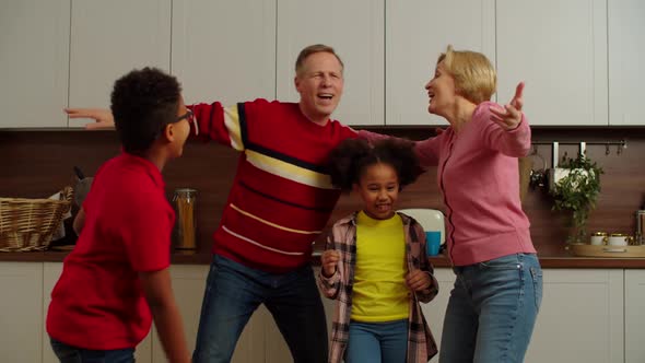 Carefree Multicultural Grandchildren with Grandparents Having Fun Dancing Indoor