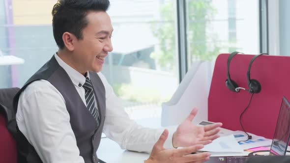 Asian young business male having a meeting by video call or conference with team in office.