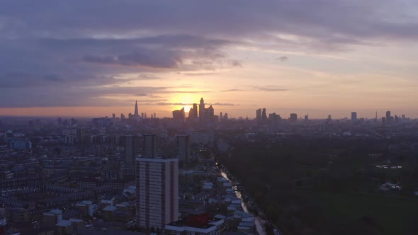 circling Aerial drone shot of London Canal towards city skyline at sunset