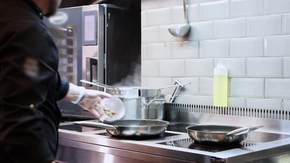 The Chef Sets Fire to the Contents in the Pan and Cooks