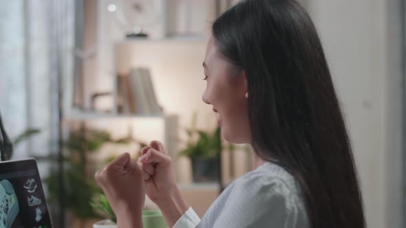 Close Up Of Asian Female Footwear Designer Celebrating Succeed Designing Shoe On A Laptop At Home