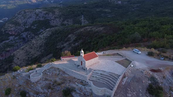 Crane Shot of an Old Stone Church on the Top of the Mountain alt