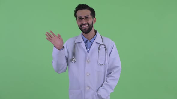 Happy Young Bearded Persian Man Doctor Waving Hand