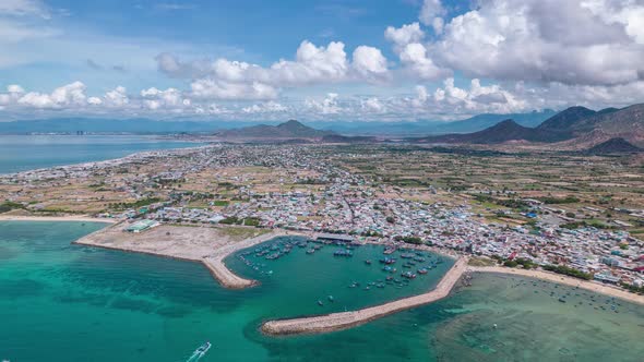 Coastal village with harbor protected by breakwater and azure water, Vietnam