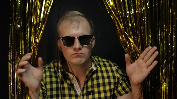 Portrait of Caucasian Man Posing on Black Background. Gold Shining Foil Strips, Party, Music, Disco