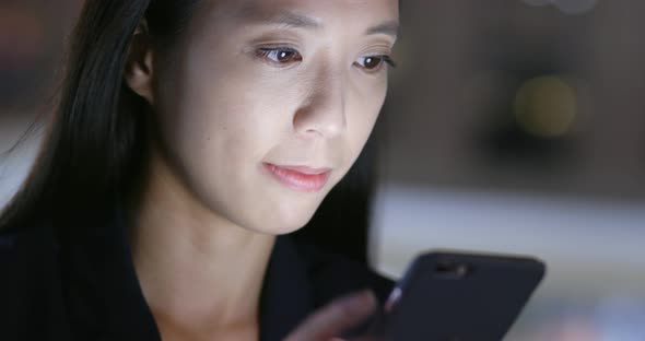 Businesswoman use of smart phone in city at night 