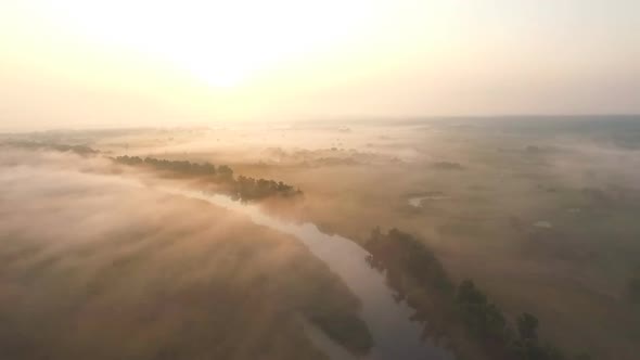 Aerial Shot of Beautiful Endless Meadow Covering with Fog at Sunrise Time. Amazing Scenic View on