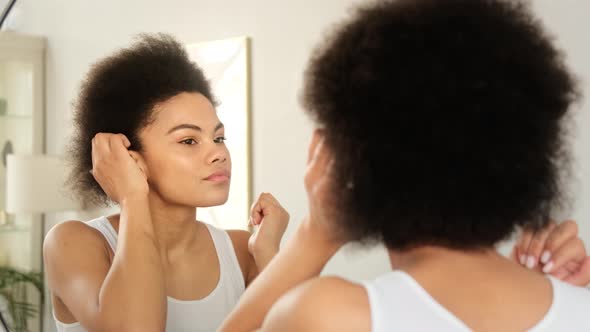 African american woman styling curly afro hair. Makes hairstyle.