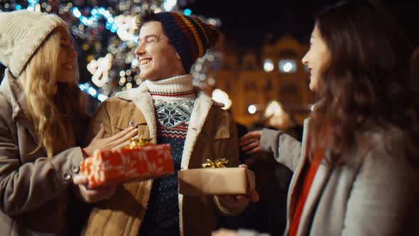 Three Friends with Gifts at Christmas Night at Old Town Square