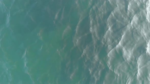 The Camera Flies Up Vertically Upwards. Top-down View of the Sea Waves. Sea Ripples. Aerial View