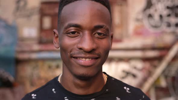 Portrait of a young black guy who smiles and looks directly at the camera