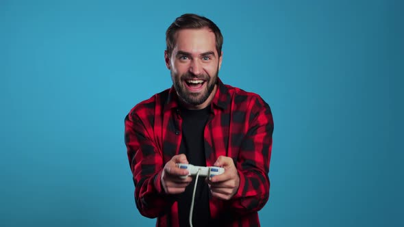 Handsome Young Man Playing Video Exciting Game on Tv with Joystick on Blue