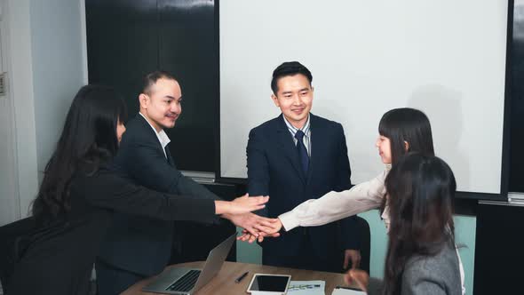 Business people join punching fists bump hands as team their meeting