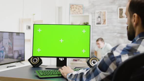 Zoom in Shot of Man Typing on Green Screen PC