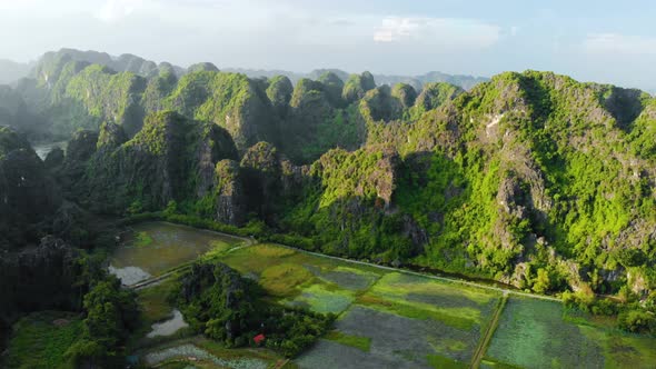 Aerial: North Vietnam karst landscape at sunset, drone view of Ninh Binh region, tourist destination