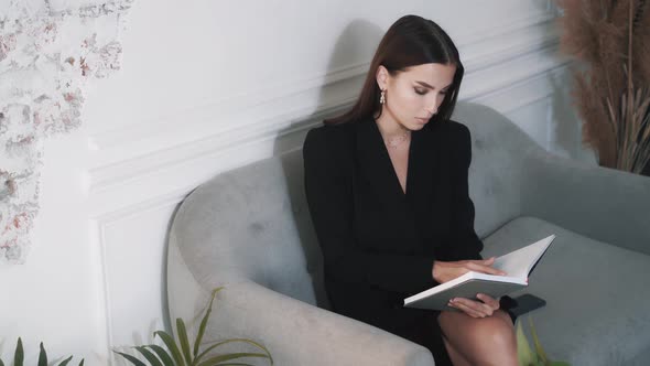 Beautiful Cute Wellgroomed Young Woman Is Reading a Book