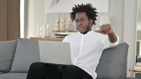 Disappointed African Man Doing Thumbs Down at Home 