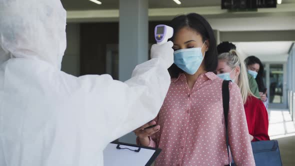 Multi-ethnic group working in casual office, in face mask protecting from Covid 19 standing in line