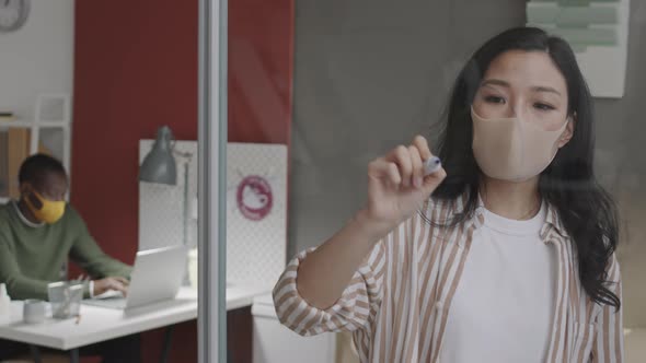 Girl Drawing on Glass in Office