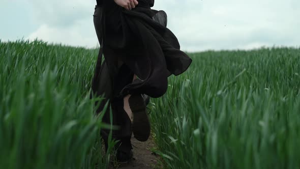 Girl In Black Dress Runs The Field. Romantic Image Of Blonde.