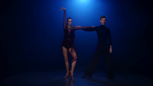 Rumba Dancing Couple of Professional Elegant Dancers in Smoky Studio