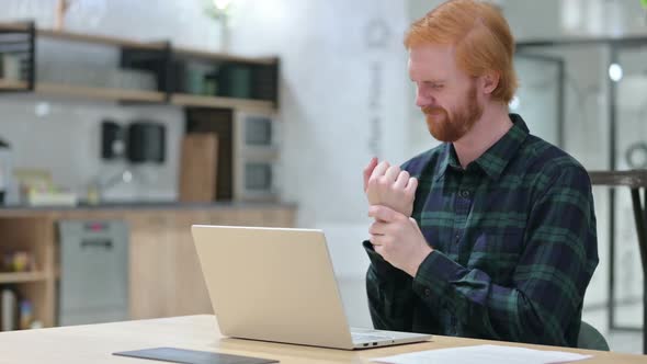 Beard Redhead Man with Laptop in Cafe Having Wrist Pain