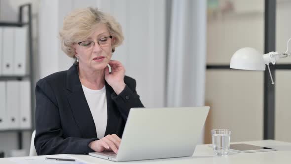 Old Businesswoman Having Neck Pain While Working on Laptop