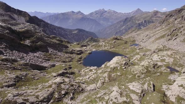 Italy Alps Mountains Aerial Above Blue Lake Reveal in Summer Sunny Day