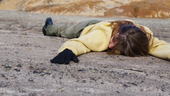Girl Exhausted From Thirst Lies in Rocky Wasteland