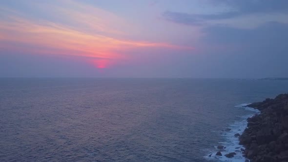 Tranquil Seascape with Steep Cliffs Against Morning Sun Aerial View