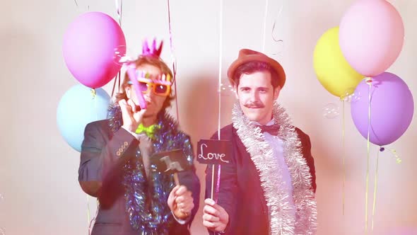 Two men holding boards in love in photo booth