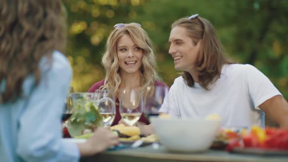 People Cheering With Drinks At Outdoor Dinner Party