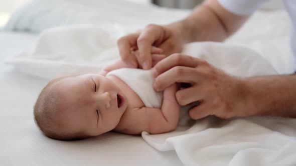 Father Holding Hands of Newborn Baby