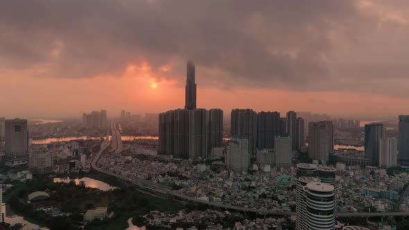 Colorful aerial urban sunrise with high rise building hidden in low cloud. Camera flies in towards h