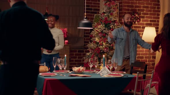 Joyful Interracial Couple Welcoming Guests to Christmas Dinner at Home