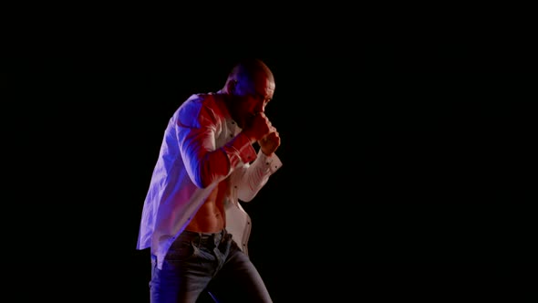 Serious Strong Man is Practicing Arm Punches Fighter in Darkness