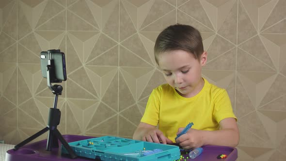 Pre-school Boy Shoots a Video Using His Smartphone While Sitting at Home. Blogger