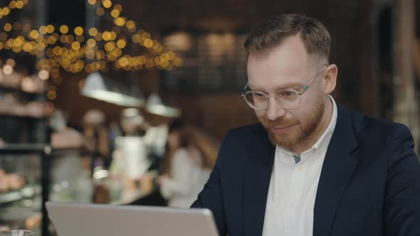 Successful Manager Working on Laptop in Cafe