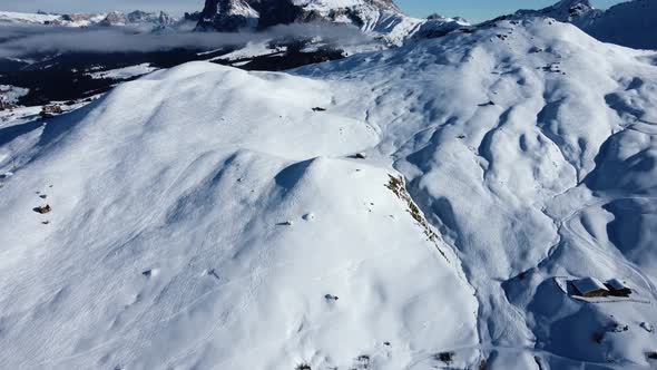 Short pan up shot from the winter season in the Italian Dolomites, slowly revealing Sassolungo in a