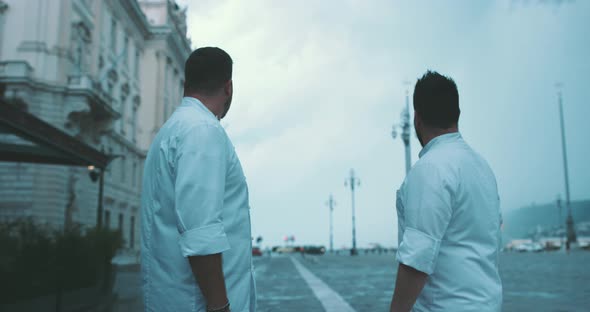 Two chefs have a conversation on city square