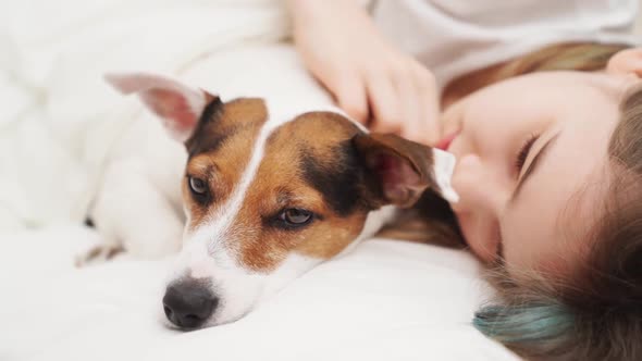 A Teenage Girl Sleeps with Her Dog in Bed