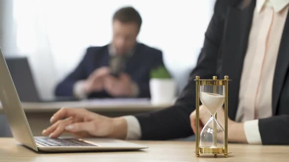 Businesswoman Working on Computer, Hourglass Trickling, Outcome Anticipation