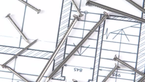 Metal Nails on Building Plan, Close Up, Rotation