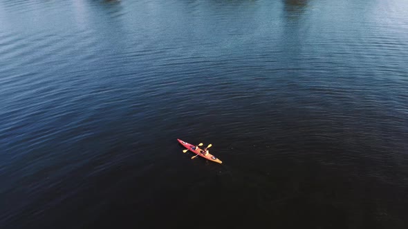 Two guys are canoeing on the river. Drone view.