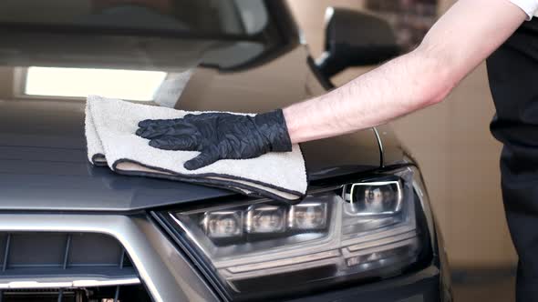 Man Wipes a Car in a Garage