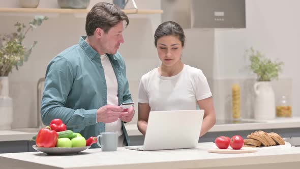 Mixed Race Couple Making Online Payment on Laptop